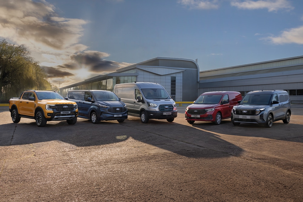 Ford Range: Ranger, Transit Custom, Transit, Transit Connect und Transit Courier – stehen auf einem Parkplatz, ein Gebäude im Hintergrund.