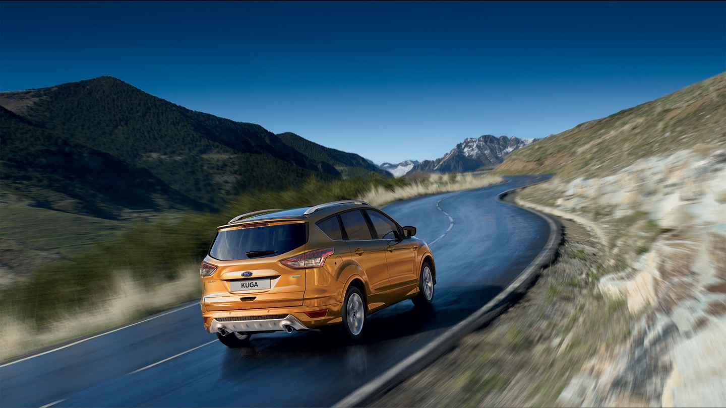 Orange Ford Kuga driving in the mountains