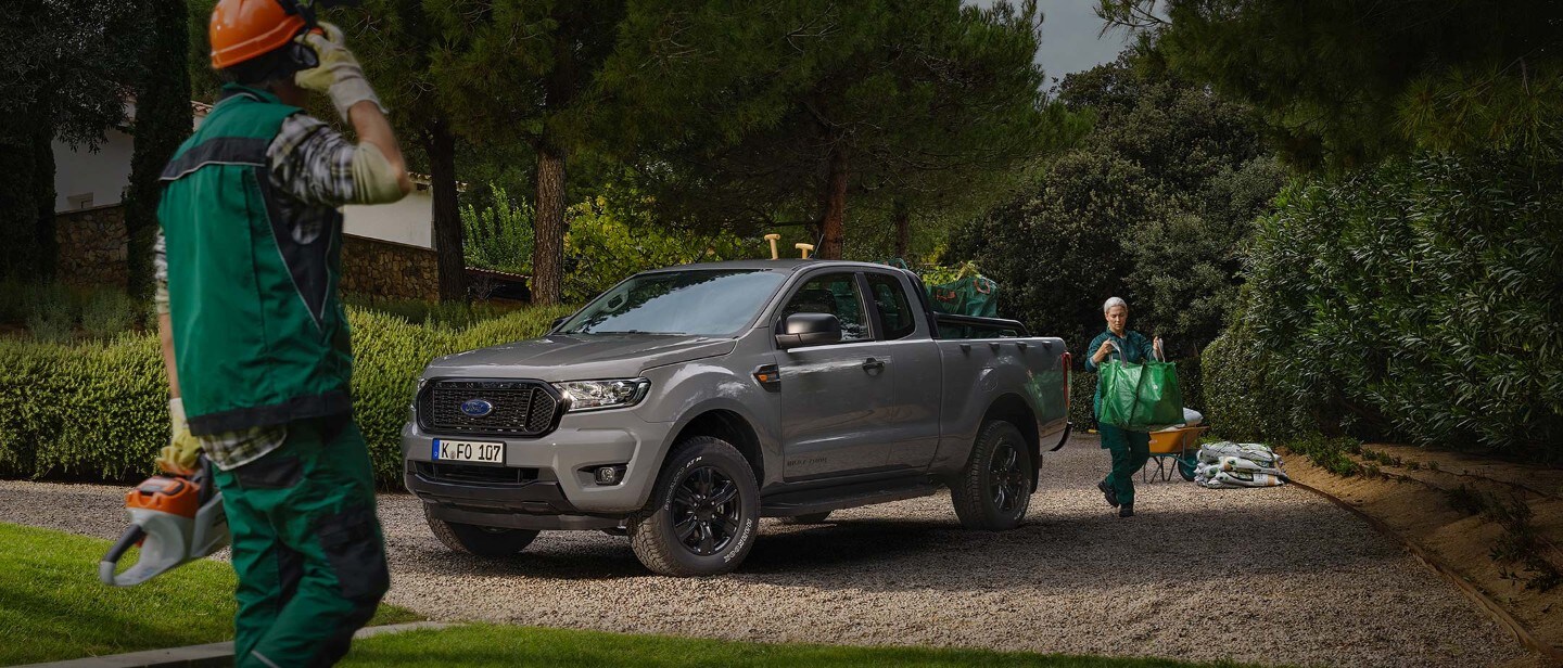 Two gardeners working beside a parked grey Ford Ranger