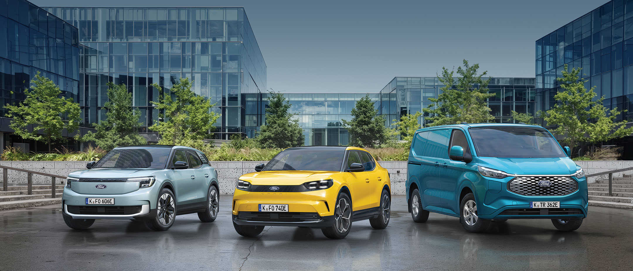 Ford Explorer, Ford Capri und Ford E-Transit Custom stehen vor einem Bürogebäude