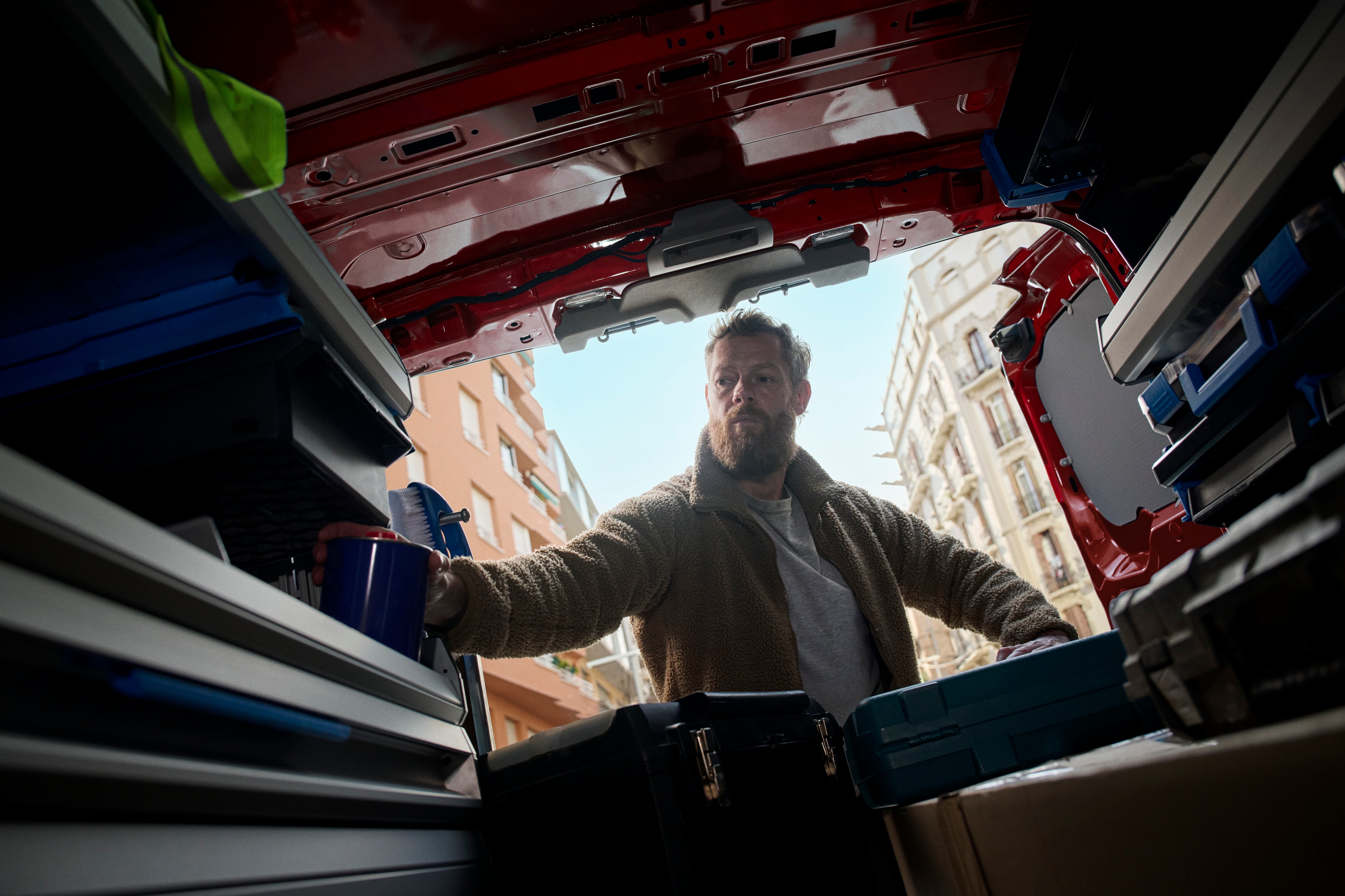 Arbeiter greift in das Regal eines Transporters