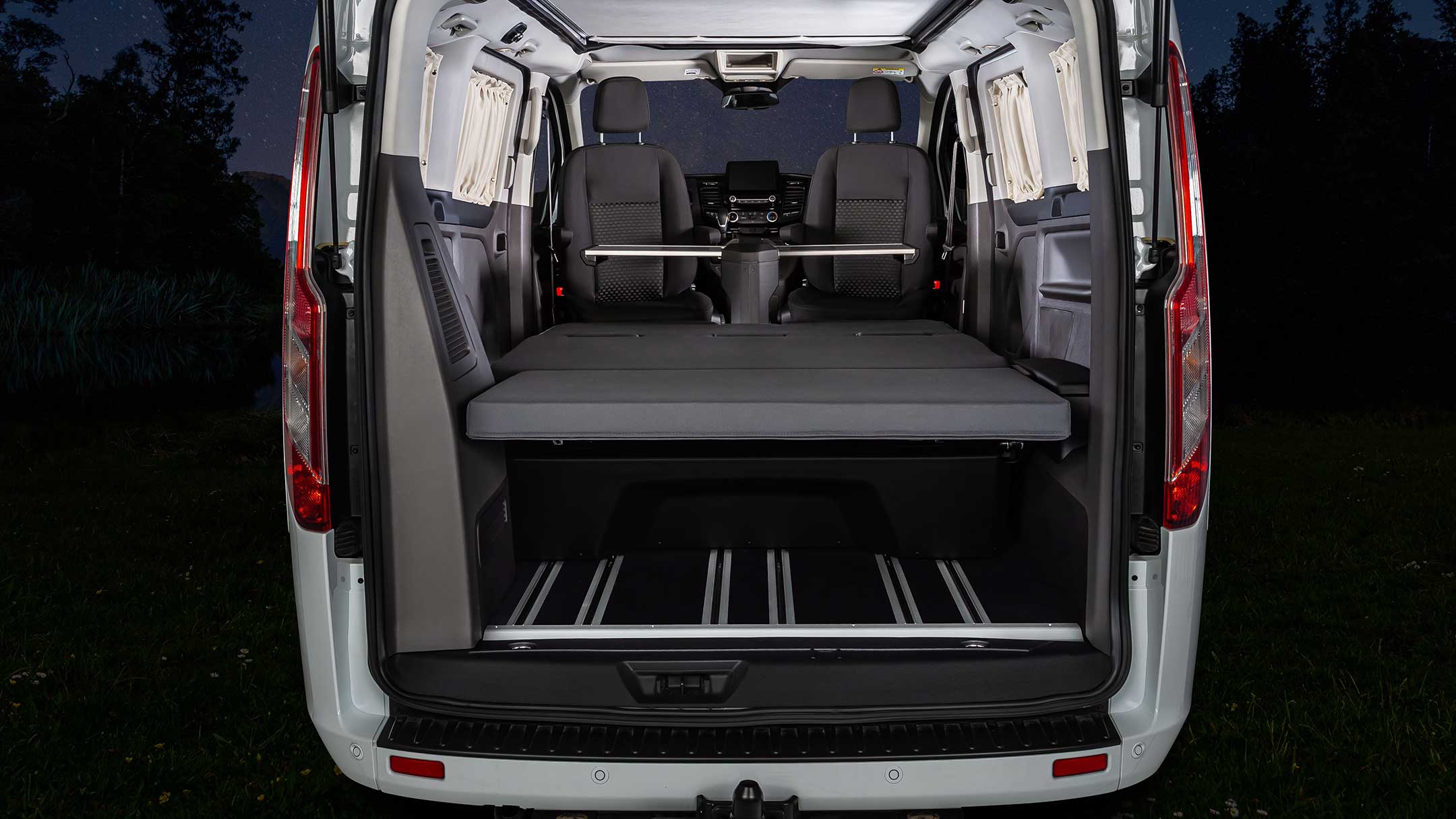 Ford Tourneo Custom Euroline in Weiß Heckansicht in den Innenraum mit ausgeklappter Liegefläche 