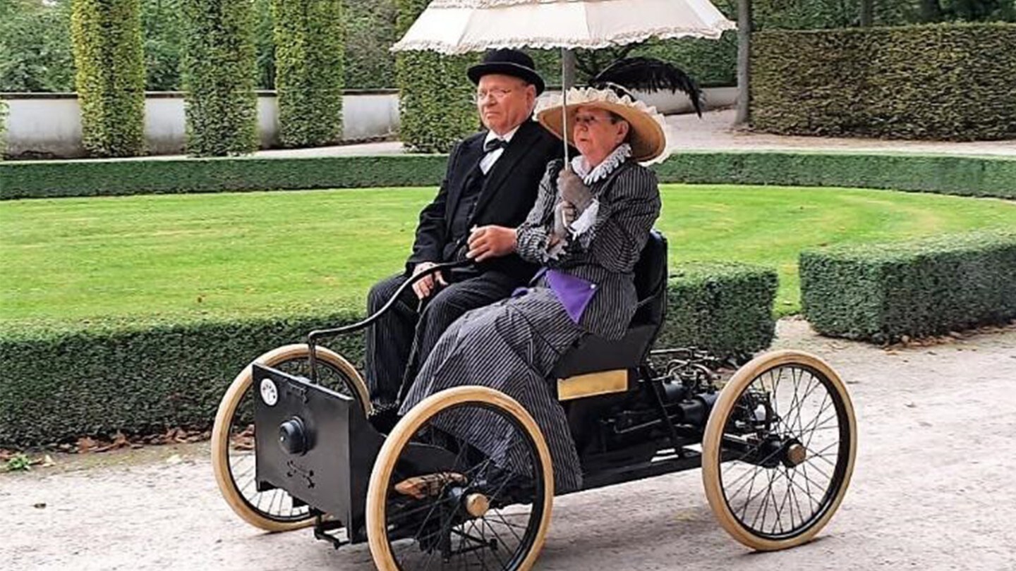 People in old Ford vehicle