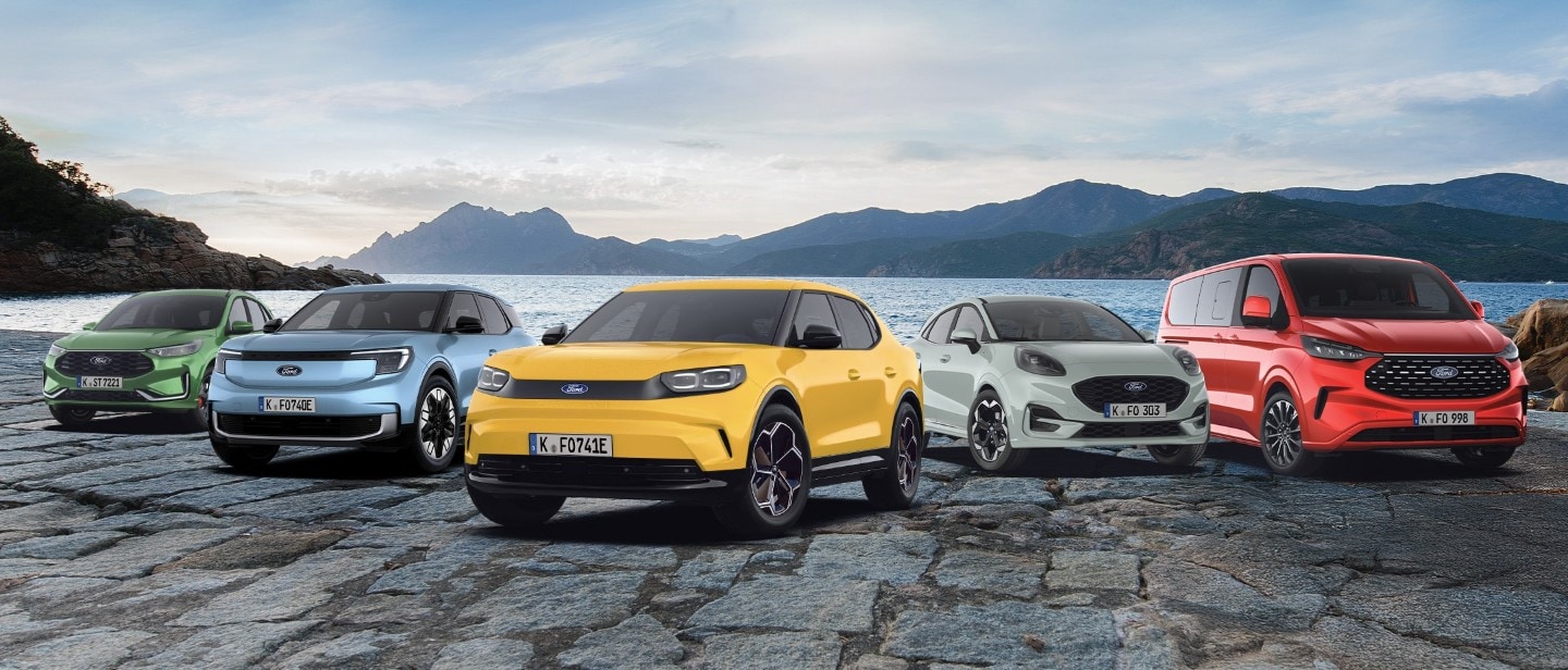 Eine Werbeaufnahme von fünf Ford-Fahrzeugen (Kuga, Explorer, Capri, Puma und Tourneo Custom) vor dem Hintergrund einer Küstenlandschaft. Die Autos sind in verschiedenen Farben gehalten, darunter Grün, Blau, Gelb, Weiß und Rot.