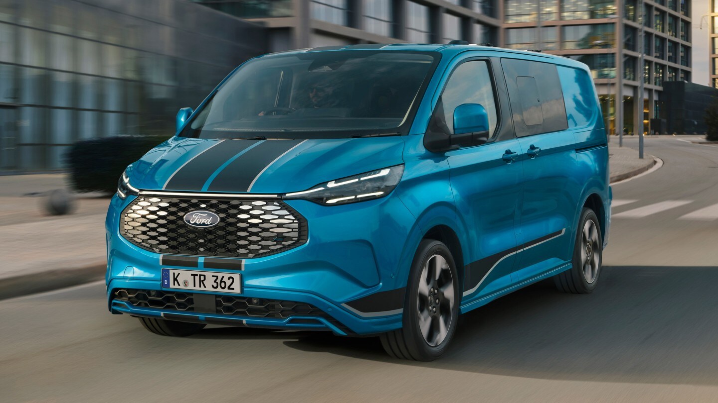 Ford Transit Custom in Blau in der ¾-Frontansicht fährt durch Stadt