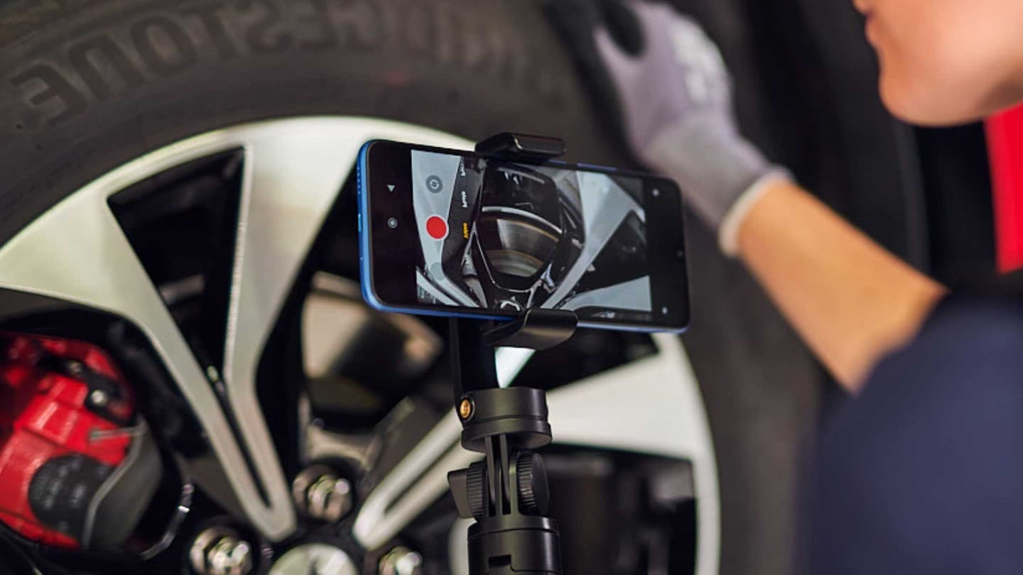 Ford Servicetechniker, der eine Inspektion unter dem Fahrzeug durchführt