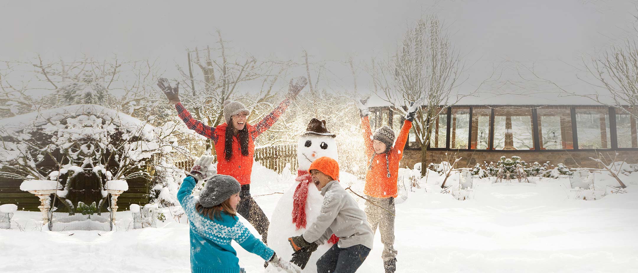 Kids playing next to a snowman