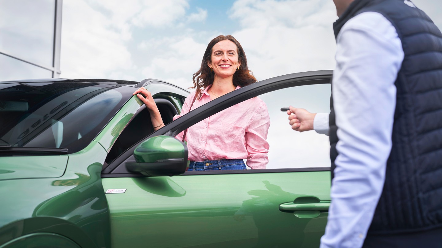 Eine Kundin erhält den Schlüssel zu ihrem Ford nach der Wartung.