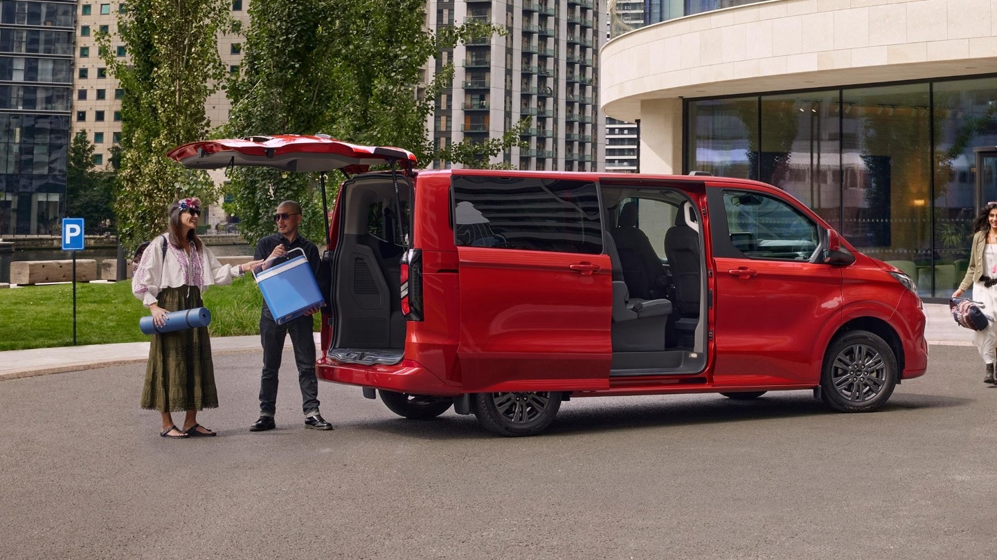 Mann und Frau beladen roten Ford Transit
