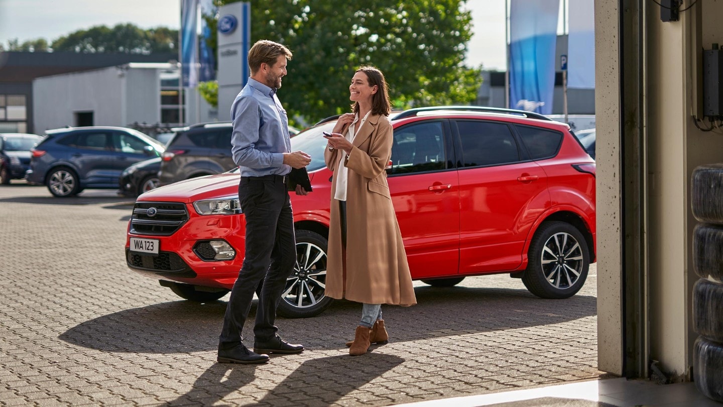 Mann mit Mobiltelefon in Ford Fahrzeug