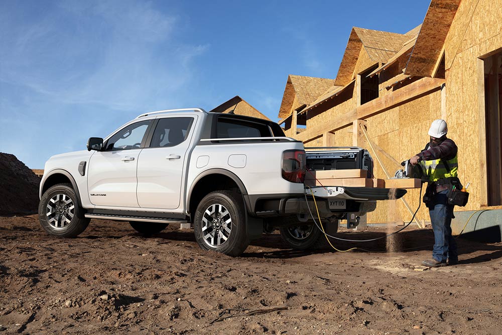 Weißer Ford Ranger auf einer Baustelle mit Bauarbeitern im Hintergrund
