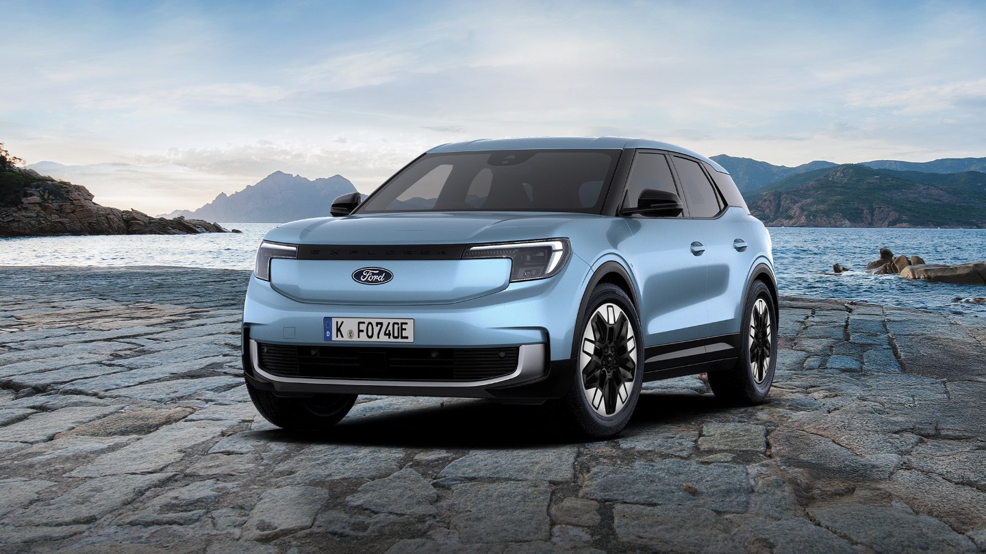 Zu sehen ist der blaue Ford Explorer SUV mit Bergpanorama und Wasser im Hintergrund.