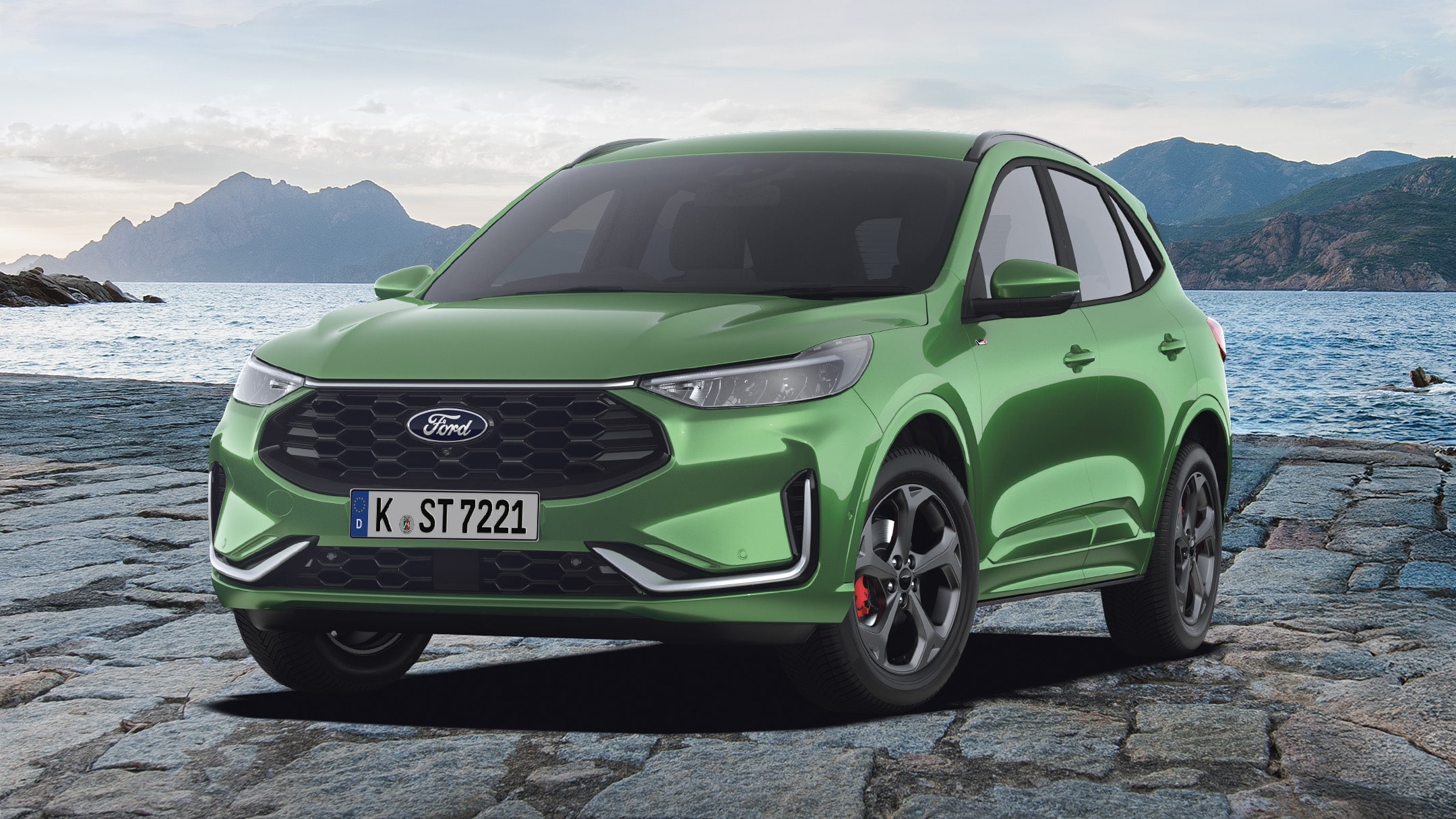 Ein grüner Ford Kuga, der Ford Bestseller-SUV, steht auf Pflastersteinen. Im Hintergrund sind Berge und Wasser zu sehen.