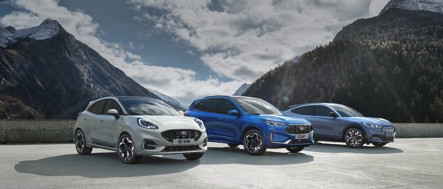 Ford Mustang Mach-E, Ford Kuga and Ford Puma parked, with mountains in the background