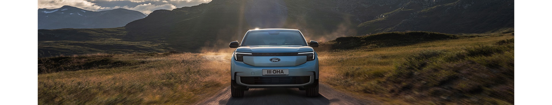 Zu sehen ist ein blauer Ford Explorer auf einem unbefestigten Weg.