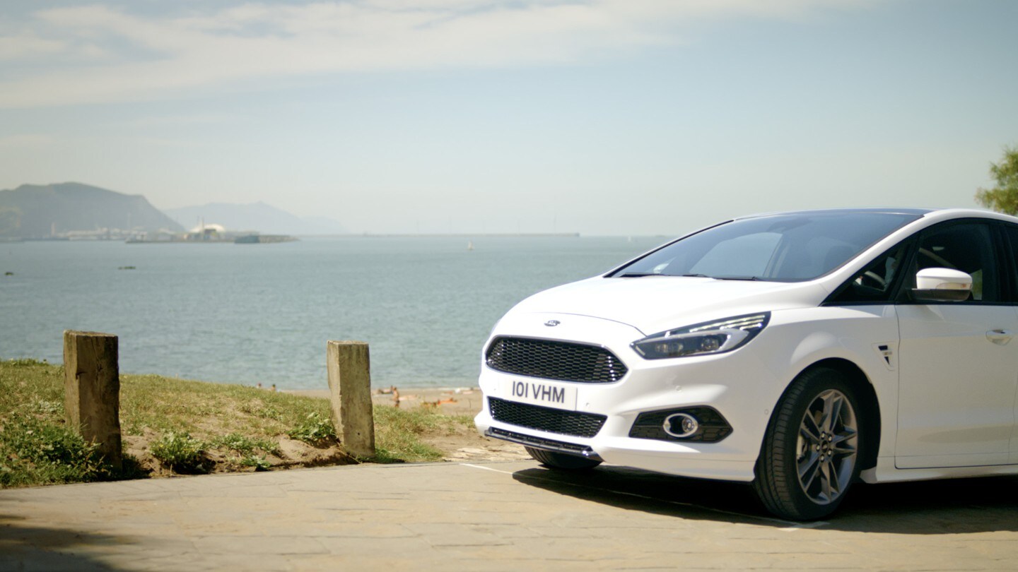 Ford S-MAX Hybrid Weiß Außenansicht parkend auf einem Berg am Meer
