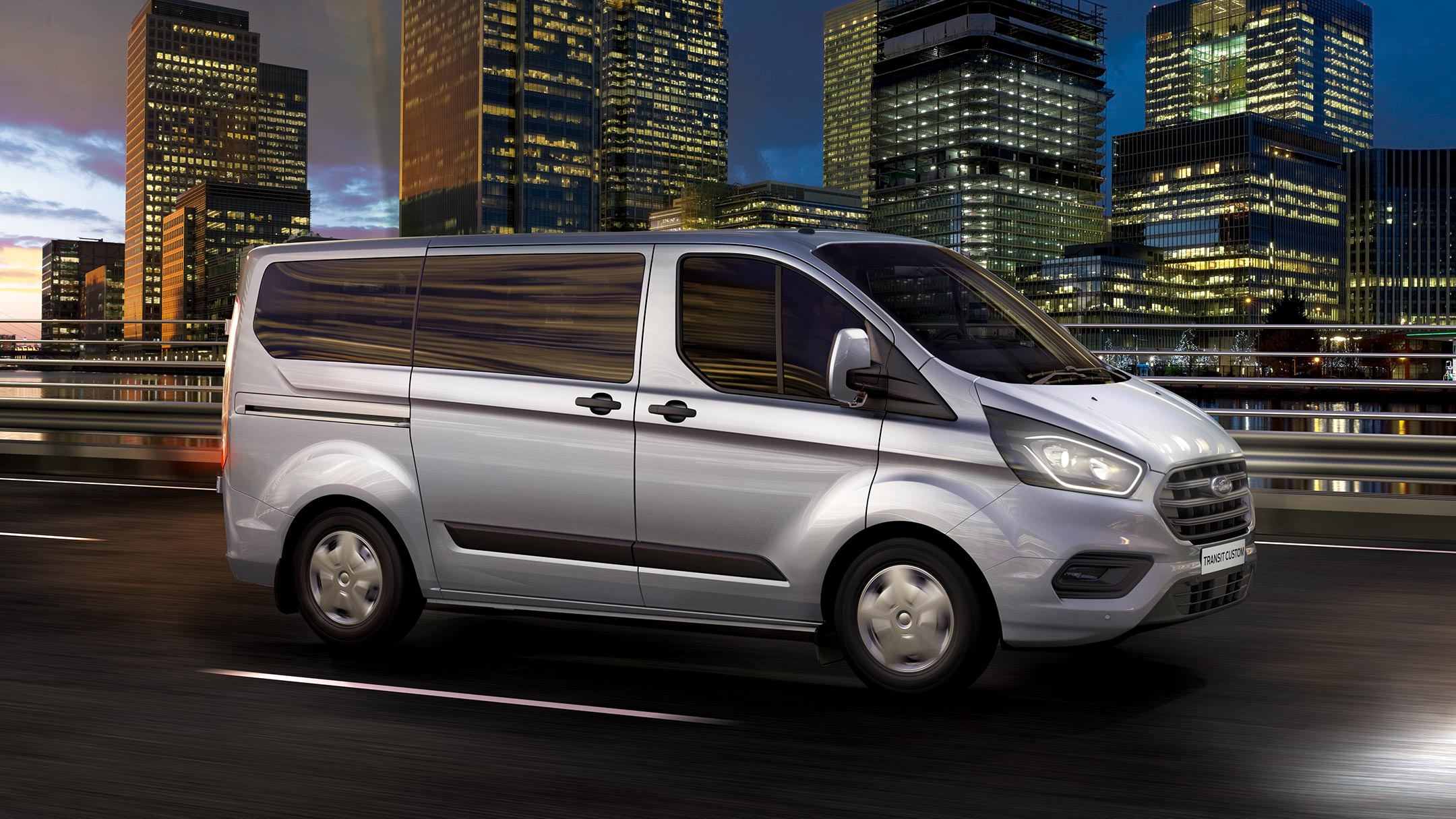 Ford Transit Custom Kombi Silber Seitenansicht bei Nacht in Bewegung auf Stadtautobahn
