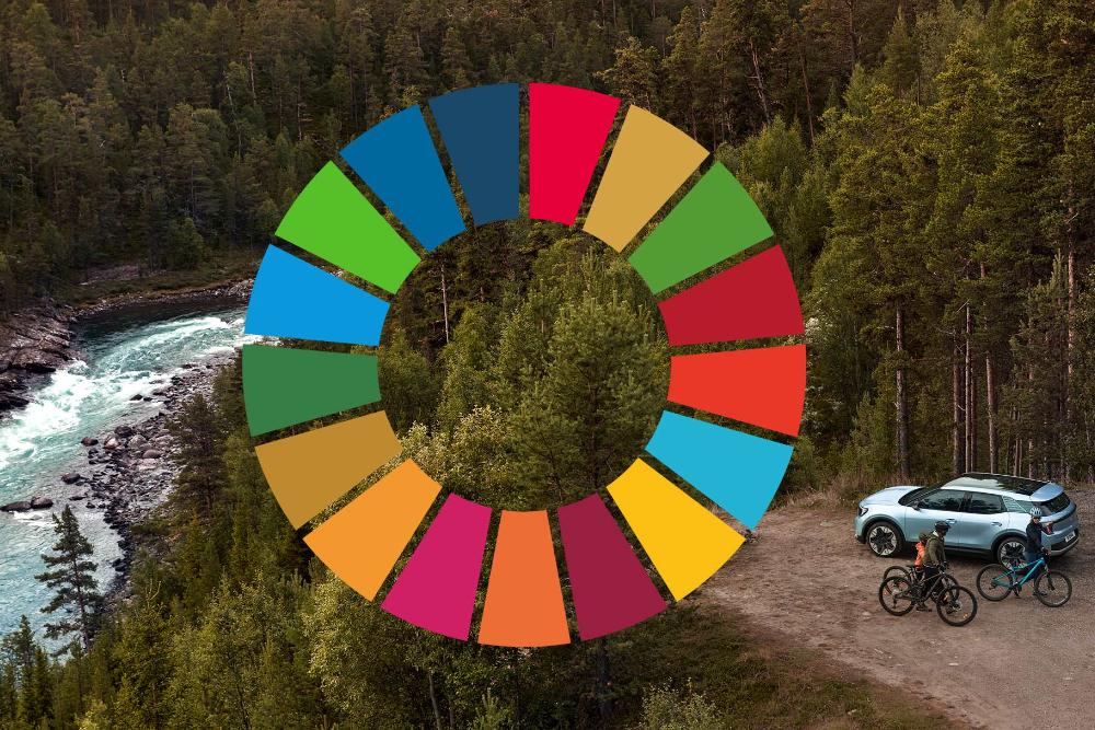Der neue Ford Explorer in Hellblau in der Vogelperspektive parkt im Wald am Rande eines Flusses mit zwei Mountainbikern