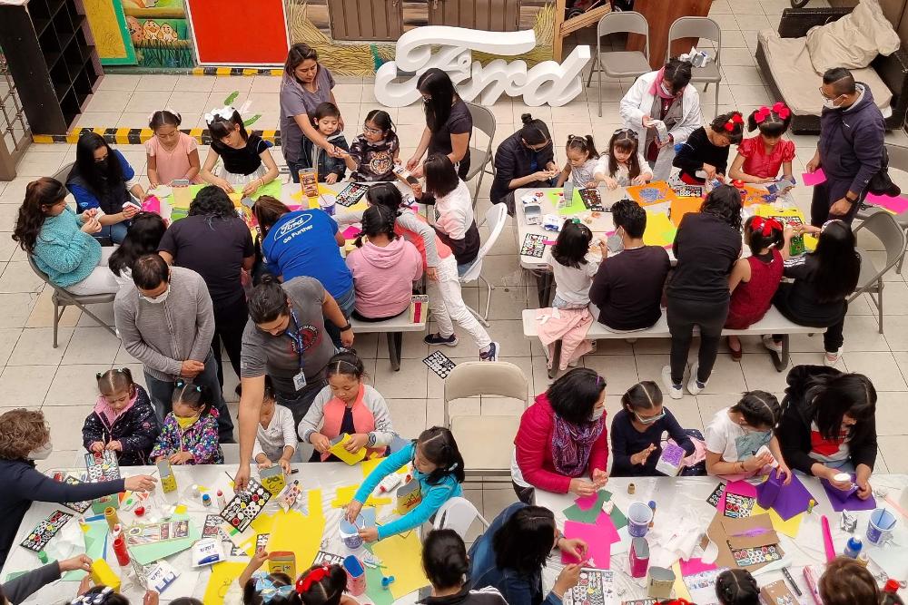 Vogelperspektive auf eine große bastelnde Kindergruppe mit Betreuern
