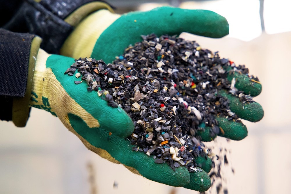 Zwei Hände halten recyceltes Kunststoffgranulat