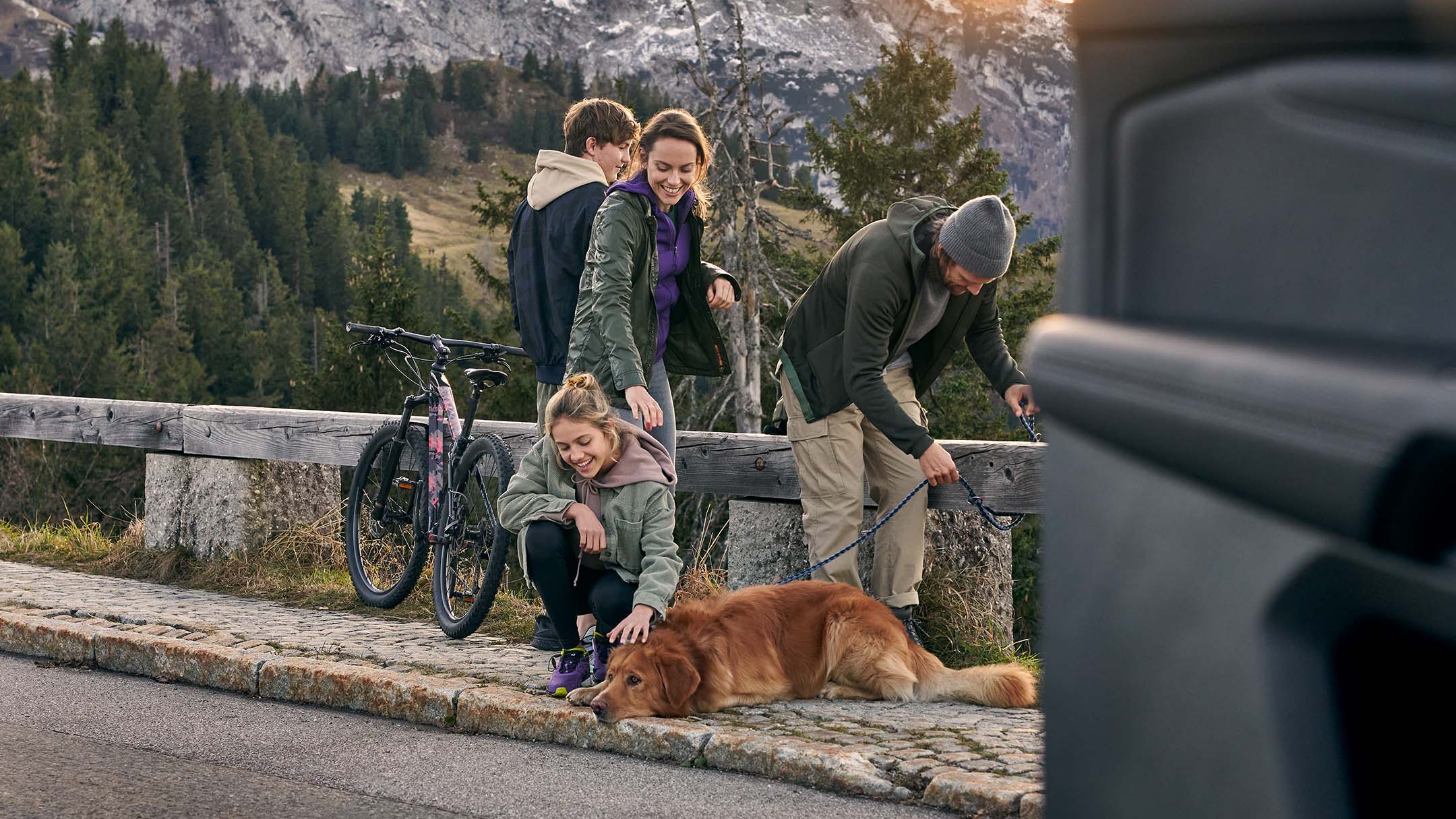 Familie und Hund auf Straße in den Bergen