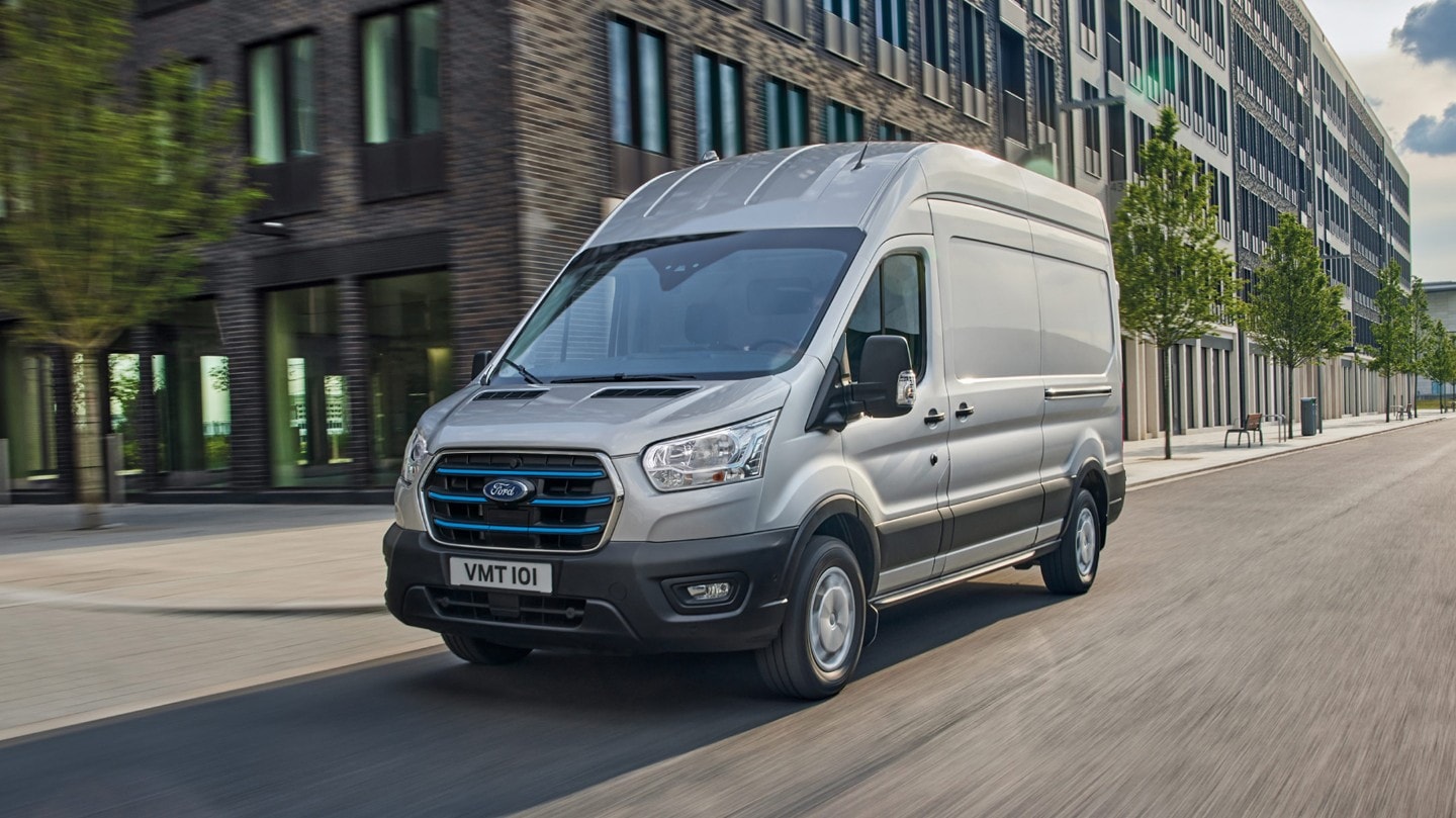 Ford Transit in Grau ¾-Frontansicht fahrend auf Straße in Stadt