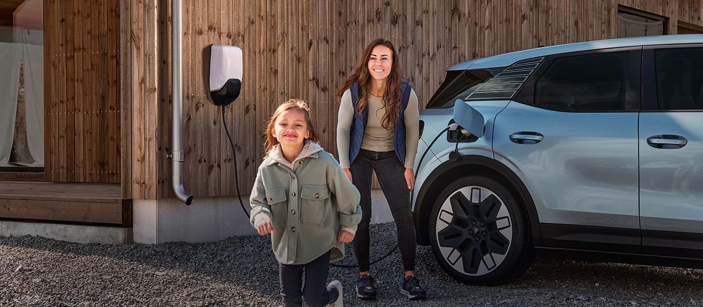 Eine Familie hat Spaß beim Aufladen ihres elektrischen Ford Explorer zu Hause.