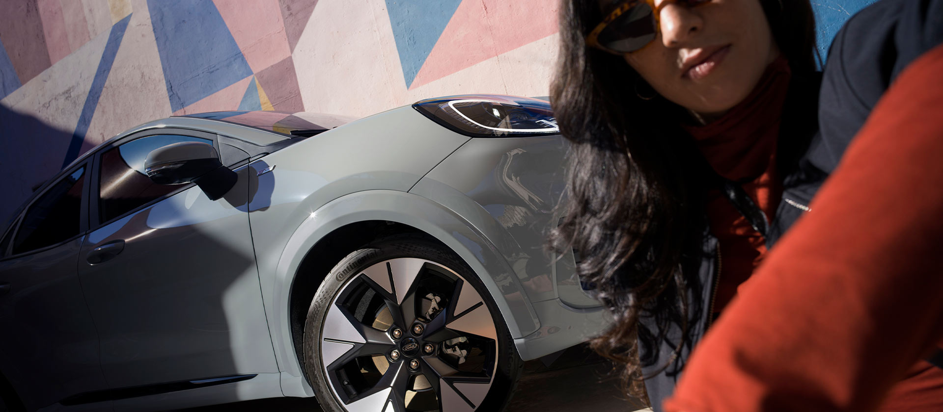 Eine Person sitzt neben einem  Ford Puma Mild-Hybrid-Fahrzeug. 