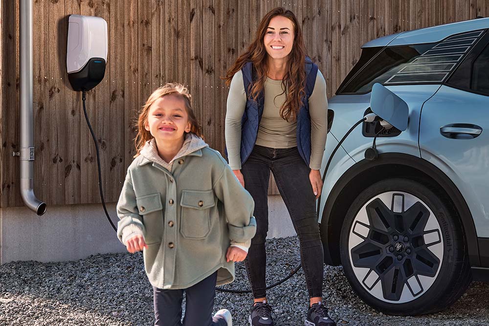 Eine Familie hat Spaß beim Aufladen ihres elektrischen Ford Explorer zu Hause.