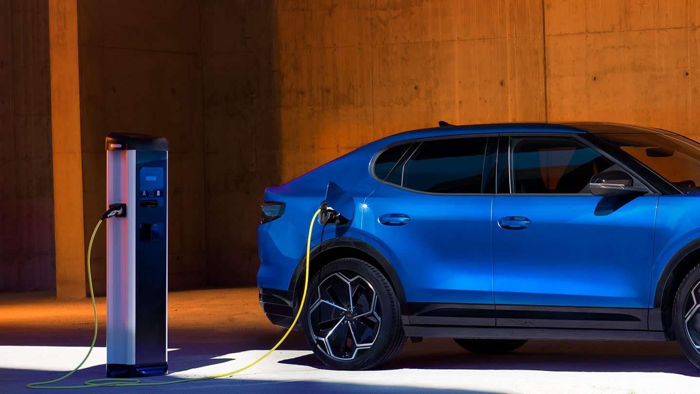 Ein blaues Ford Capri Elektrofahrzeug ist an einer EV-Ladestation angeschlossen. 