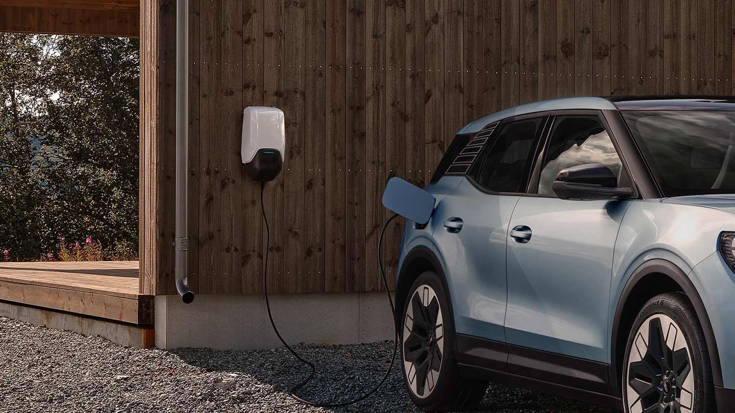 Ein blauer elektrischer Ford Explorer ist an ein EV-Ladestation für zu Hause angeschlossen.