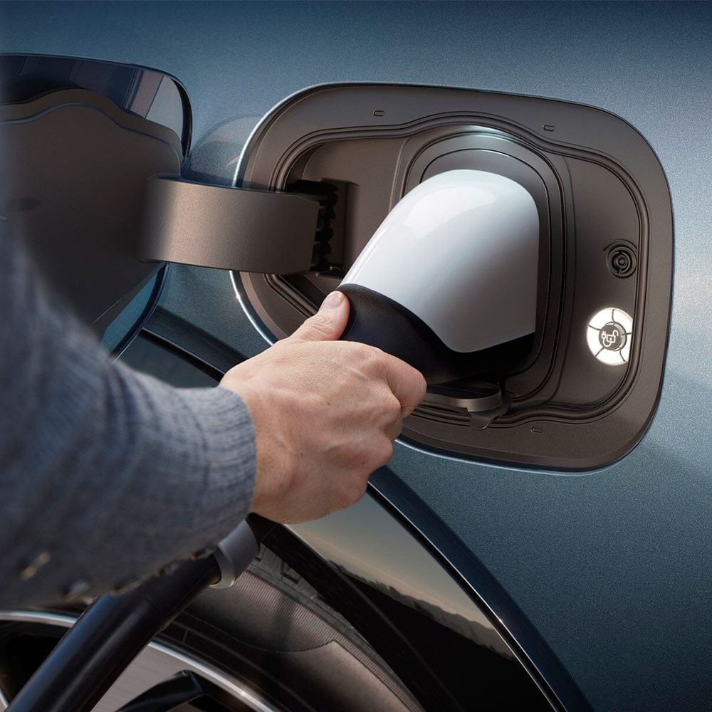 Eine Person schließt ein Schnellladegerät an ein Ford Elektrofahrzeug an.