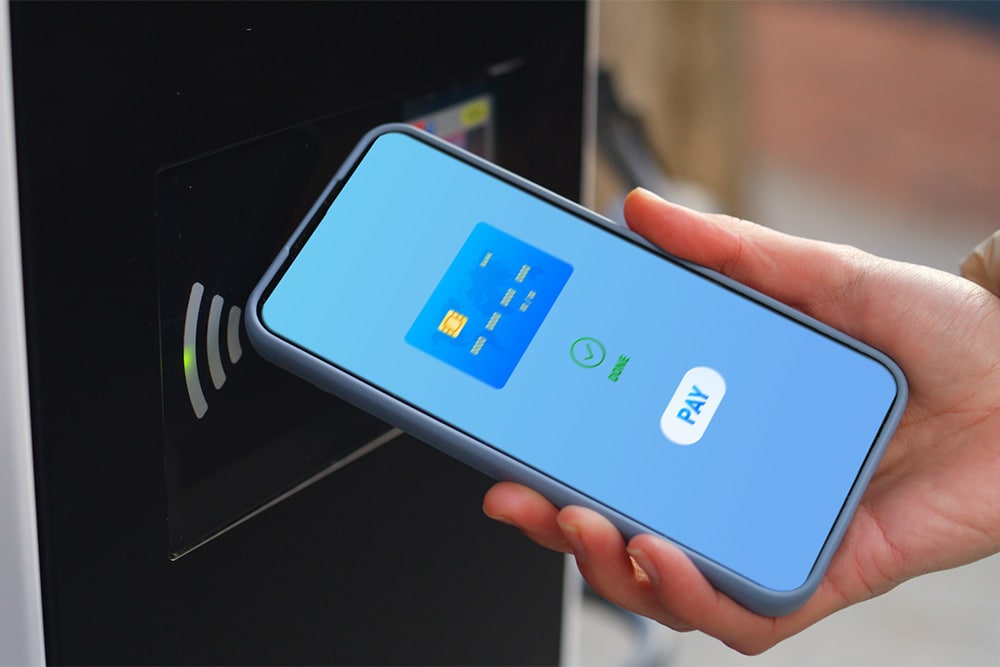 Ein Smartphone wird an einer öffentlichen Ladestation für kontaktloses Bezahlen verwendet.