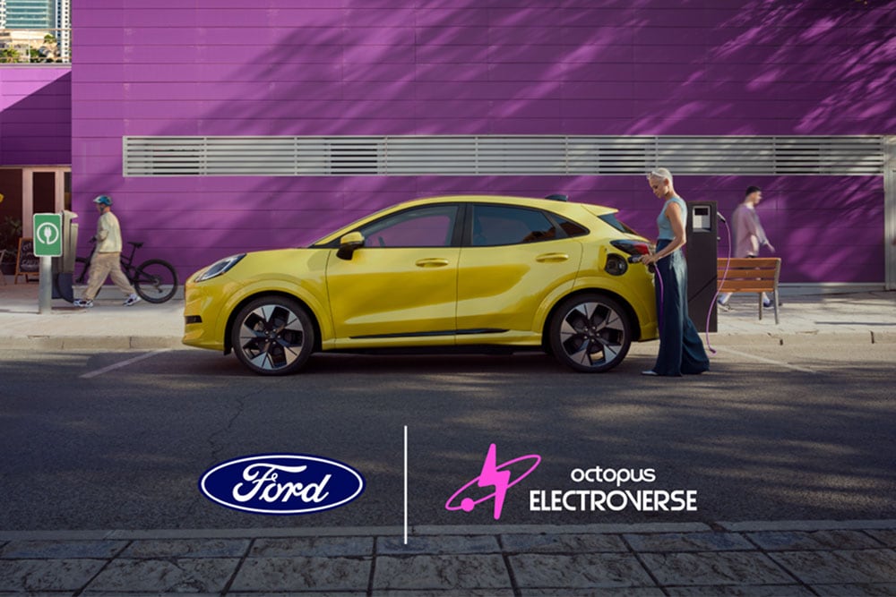 Seitenansicht eines gelben elektrischen Ford Puma Gen-E, der an einer öffentlichen Ladestation angeschlossen ist.