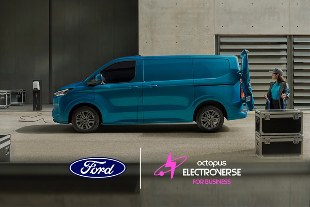 Seitenansicht eines blauen Ford E-Transit Custom, der mit offener Hecktür geparkt ist und eine Person daneben steht.