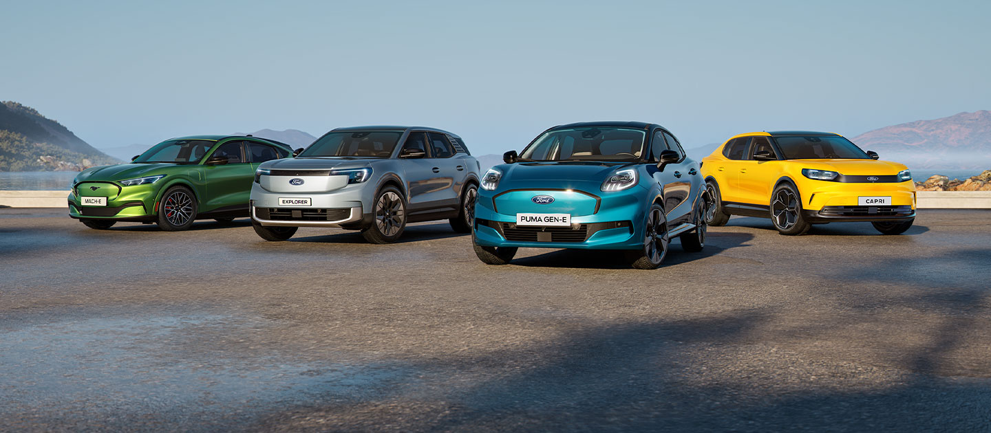 Eine Sammlung verschiedener Ford Elektroautos, die in einer rauen Küstenlandschaft geparkt sind.