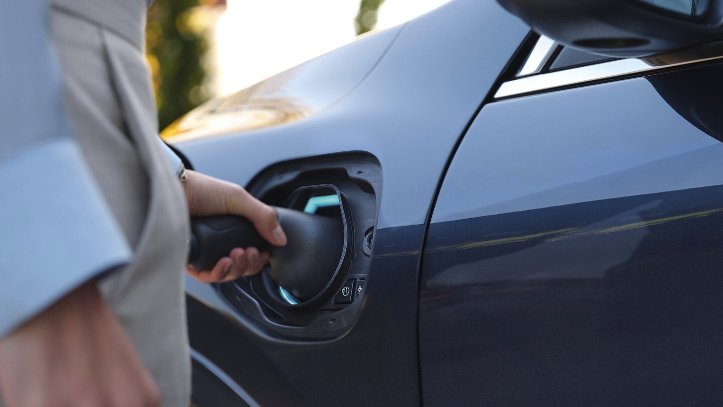 Nahaufnahme des Anschließens eines Ladekabels an ein Elektroauto
