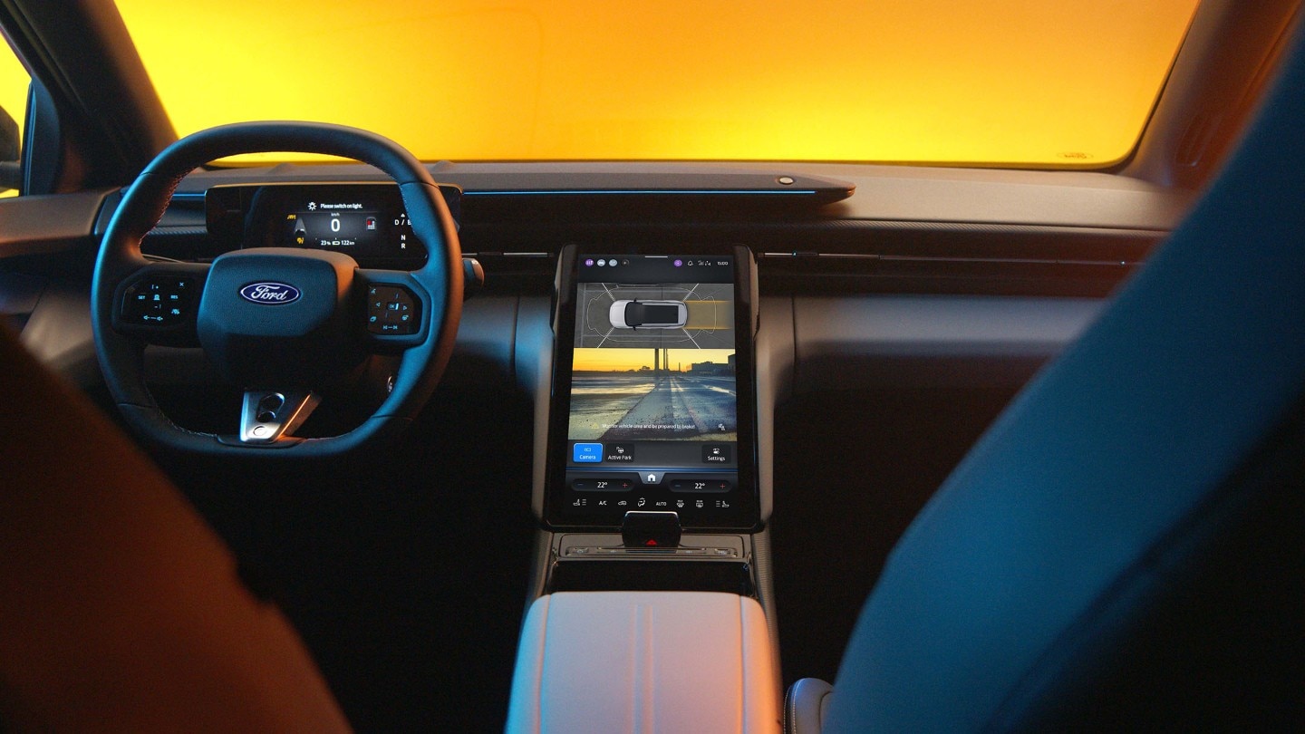 Das Interieur des vollelektrischen Ford Capri mit Lenkrad und SYNC Move-Touchscreen.