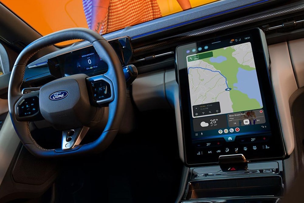 Frau mit Smartphone beim elektrischen Laden ihres Ford Fahrzeugs