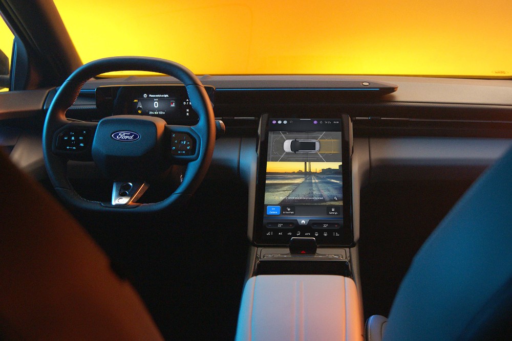 Das Interieur des vollelektrischen Ford Capri mit Lenkrad und SYNC Move-Touchscreen.