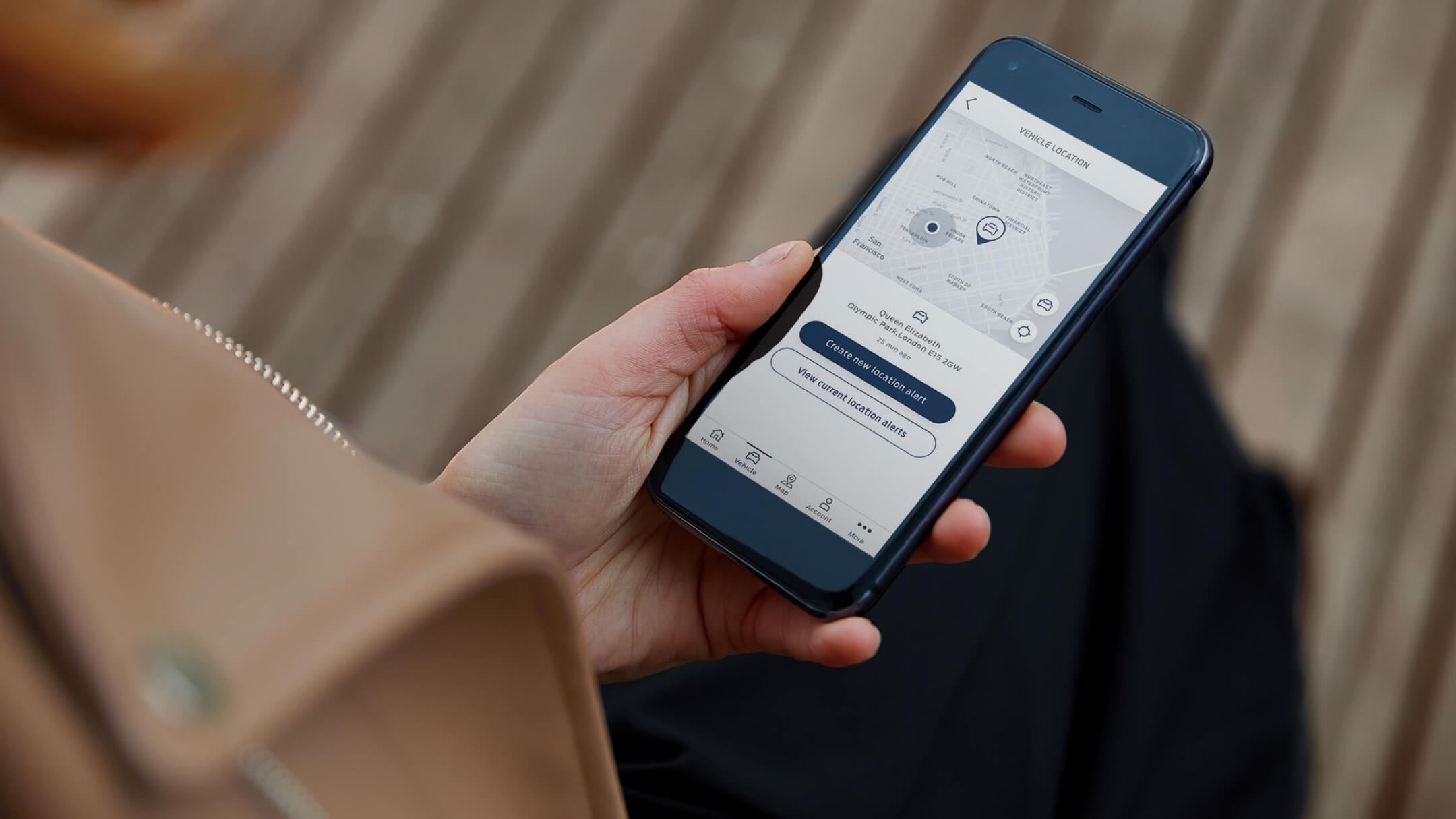 Eine Hand, die ein Smartphone hält und den Standort-Alarm in der FordPass-App anzeigt