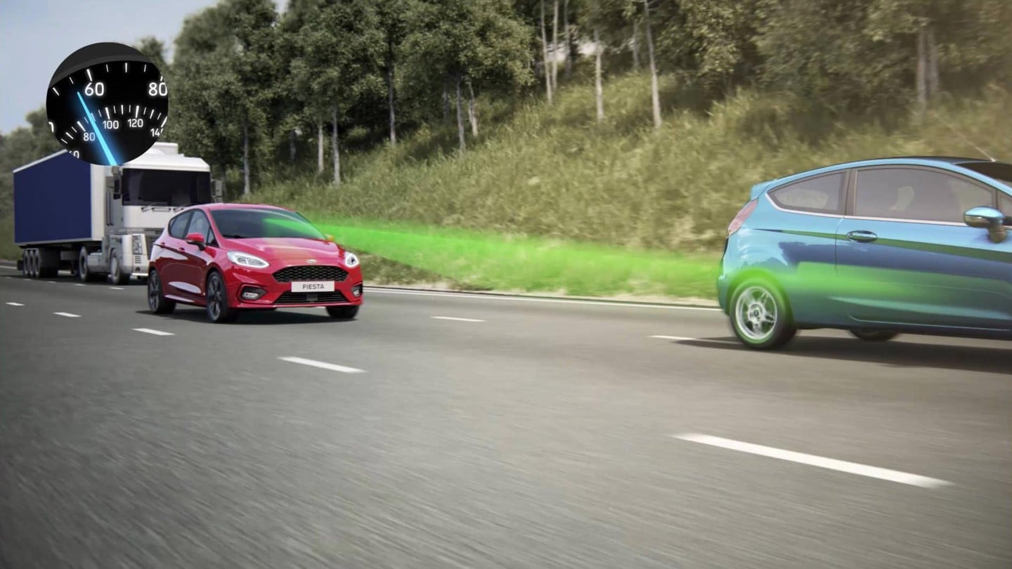 Ford Fiesta ST in Rot und Grün auf der Landstraße. Visualisierung der adaptiven Geschwindigkeitsregelanlage.