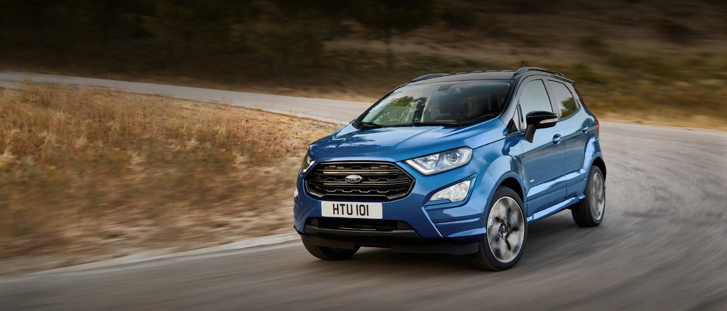 Blue Ford EcoSport driving on a country road.