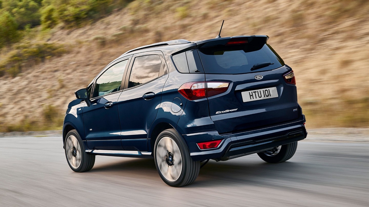 Ford Ecosport in Blau. Dreiviertelansicht von hinten. Fahrszene auf einer kurvigen Landstraße