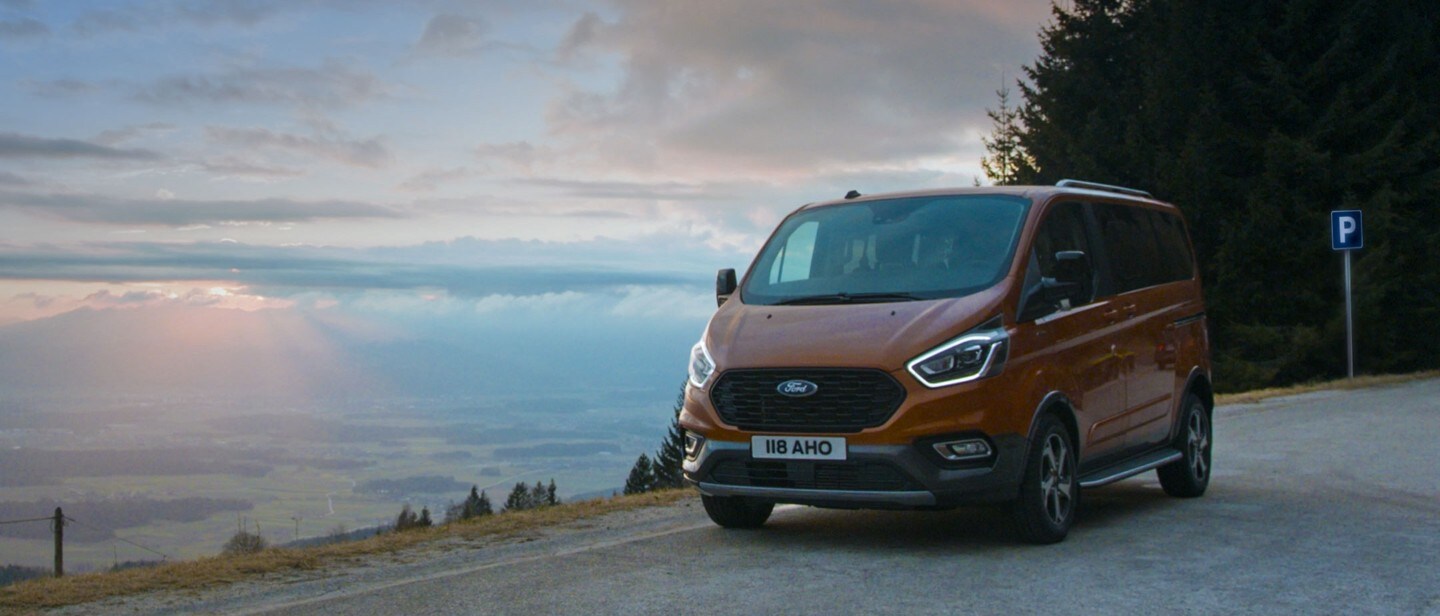 Ford Tourneo Custom Active Orange fährt über Land 