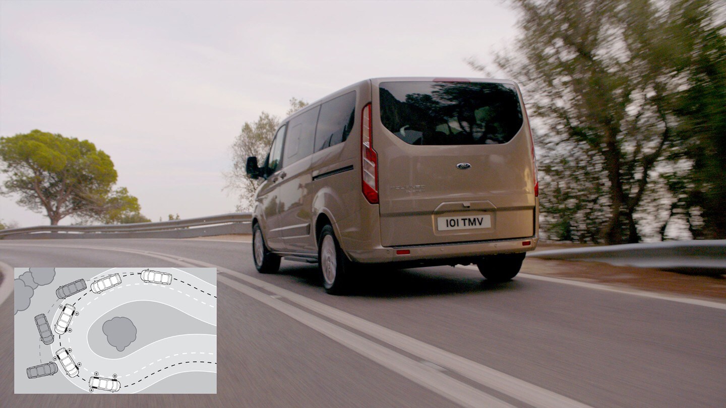 Ford Tourneo Custom Champagner ¾-Heckansicht auf Gebirgsstraße bergauf in Bewegung 