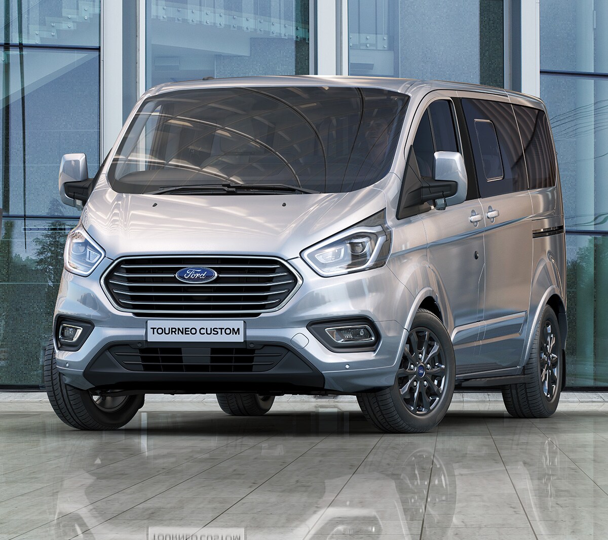 Ford Tourneo  Custom Silber ¾-Frontansicht steht in modernem Gebäude