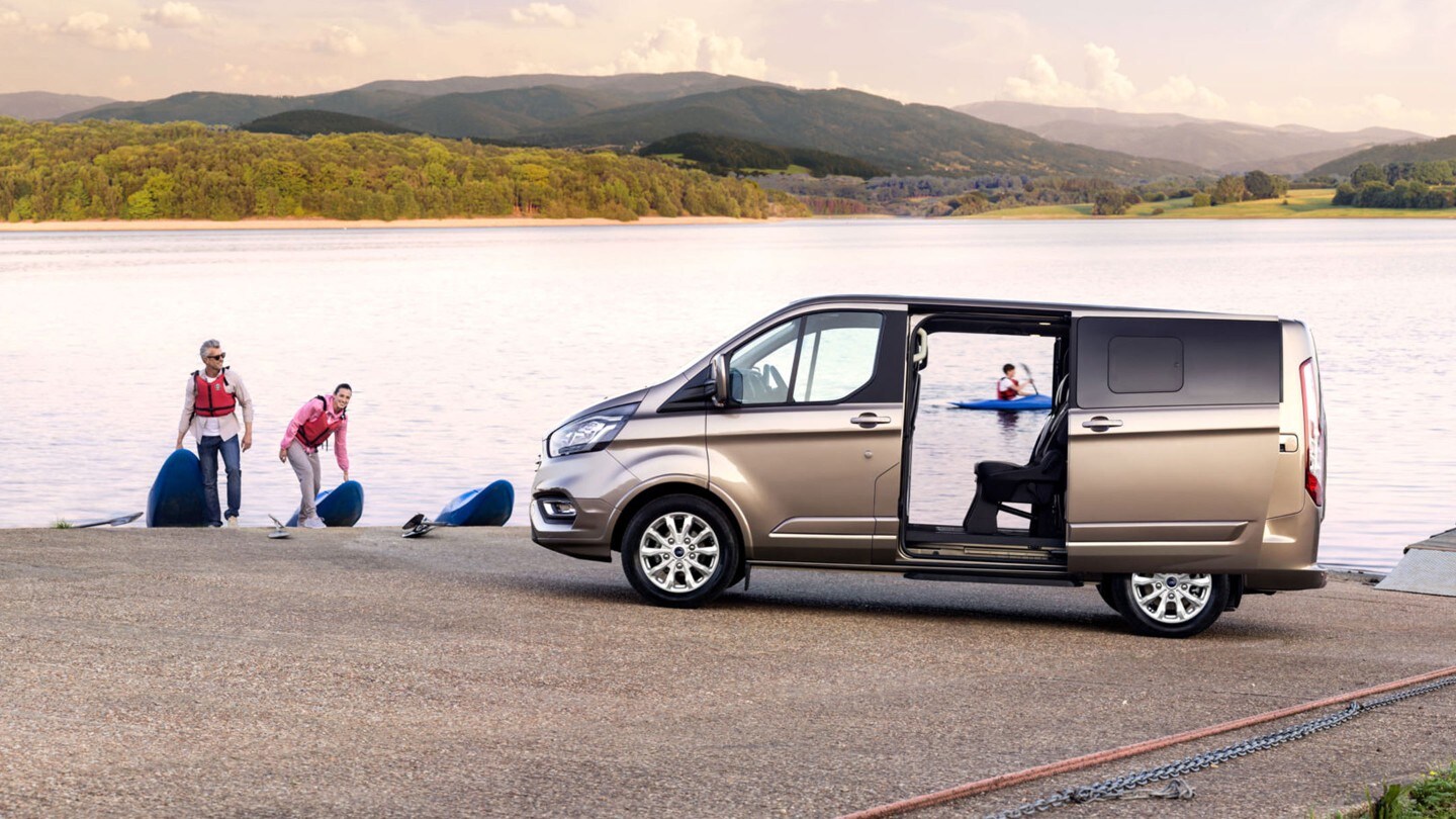 Ford Tourneo Custom Champagner Seitenansicht geöffnete Schiebetüren parkt an See