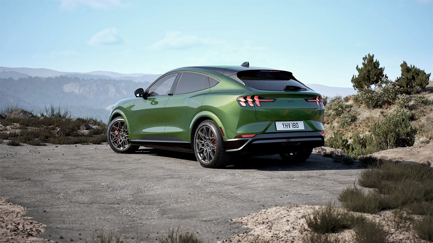 Die Rückseite des grünen Ford Mustang Mach-E GT  parkt auf einer Bergstraße.