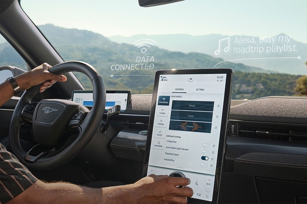 Nahaufnahme des Fahrers eines Ford Mustang Mach-E, der mit dem großen 15,5-Zoll SYNC 4 Touchscreen interagiert.